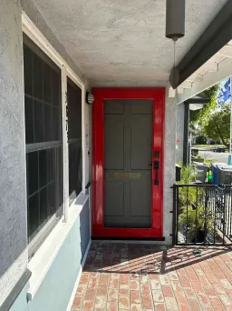 Red Centurion security screen door featuring woven stainless steel mesh