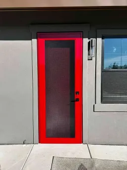 Red Centurion security screen door installed on a home