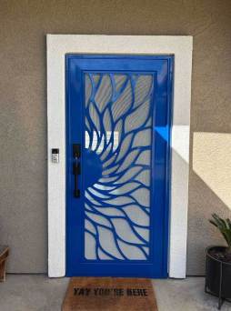 Blue Artisan security door with sunrise pattern and full visibility mesh installed on front entry
