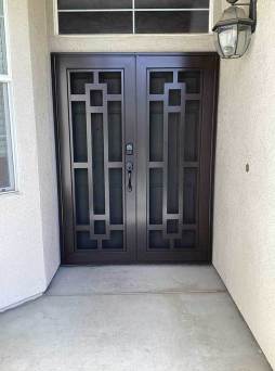 White Artisan security door with decorative pattern and airflow mesh installed on residential entry