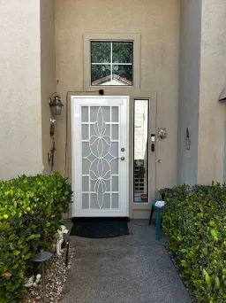 White Artisan security door with ivy pattern and stainless mesh on residential entry