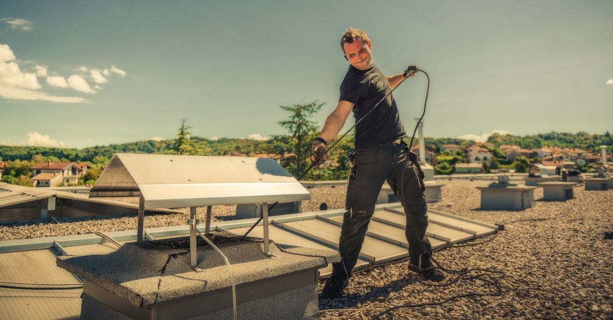 man-sweeping-chimney-on-roof-is-chimney-sweeping-a-must-for-my-tracy-home-den-defenders